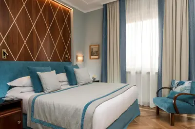 a hotel room with a bed and a chair at Bettoja Hotel Mediterraneo in Rome