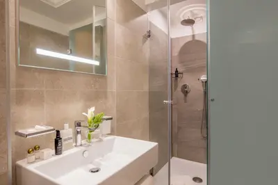 a bathroom with a sink and a shower at Ludovisi Palace Hotel in Rome