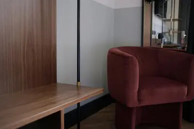 a red chair sitting next to a wooden desk at c-hotels Club House Roma in Rome