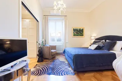 a bedroom with a bed and a flat screen tv at Casa Roma Luxury Apartment in Rome