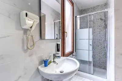 a white bathroom with a sink and a shower at Hotel Family House in Rome
