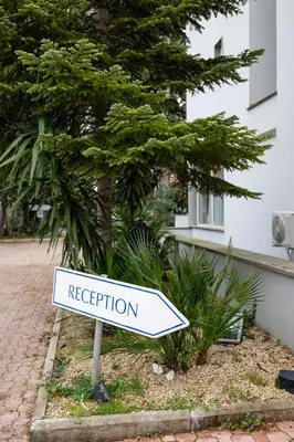 a white sign that says reception on a street at Scheppers Hotel in Rome