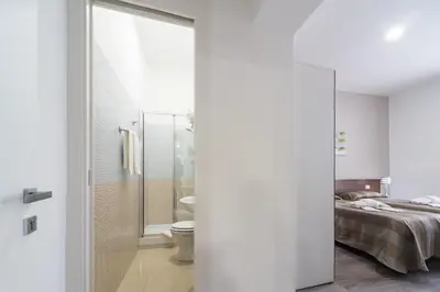 a bedroom with a bed and a bathroom with a shower at Sweet Holidays In Rome in Rome