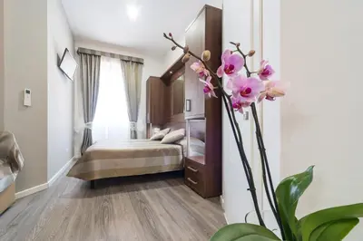 a hotel room with a bed and a vase of flowers at Sweet Holidays In Rome in Rome