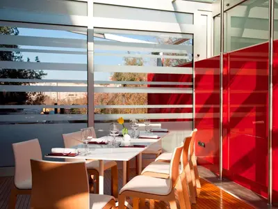 a restaurant with white tables and chairs and a red wall at Hotel Zone in Rome