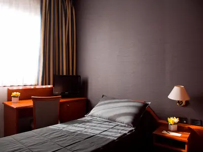 a hotel room with a bed and a desk and a window at Hotel Zone in Rome