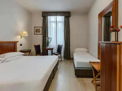 a hotel room with a bed and a table and a couch at Hotel Diplomatic in Rome