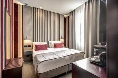 a hotel room with a bed with pink pillows at Doria Palace Boutique Hotel in Rome