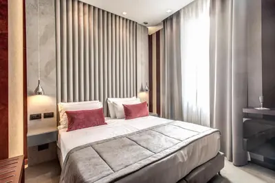 a bedroom with a large bed with two red pillows at Doria Palace Boutique Hotel in Rome