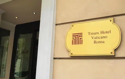 a yellow sign on the side of a building at Tmark Hotel Vaticano in Rome