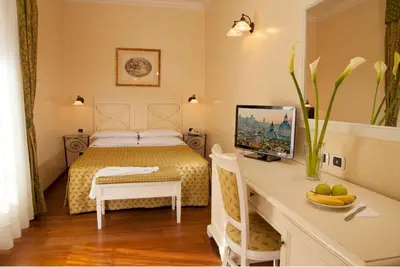 a bedroom with a bed and a desk with a computer at Hotel Piemonte in Rome