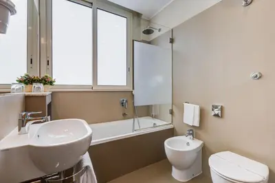 a bathroom with a sink and a toilet and a window at Best Western Hotel Piccadilly in Rome