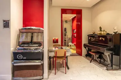 a room with a piano and a table and a dining room at Hotel White in Rome