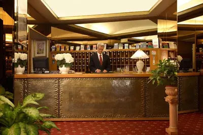 a man in a suit sitting at a bar at Hotel Eliseo in Rome
