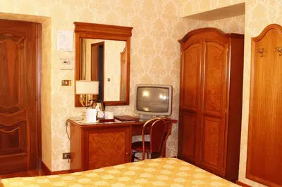 a bedroom with a desk with a tv and a bed at Hotel Pace Helvezia in Rome