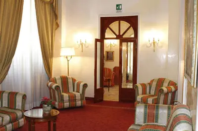 a living room with two chairs and a table at Hotel Pace Helvezia in Rome