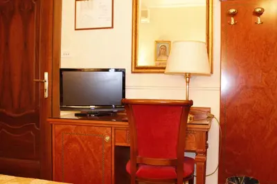 a room with a desk with a television and a red chair at Hotel Genio in Rome