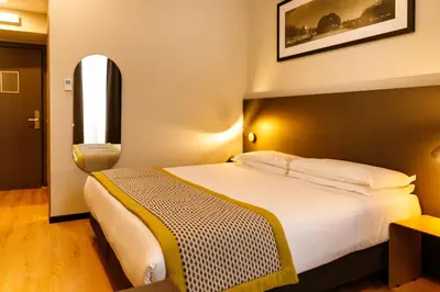 a hotel room with a large bed and a window at The Cross Hotel in Rome