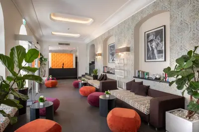 a lobby with couches and tables and plants at The Republic in Rome