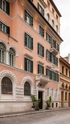 a pink building with windows and plants in front of it at Hotel Viminale in Rome