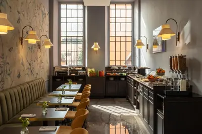 a restaurant with tables and a kitchen with windows at Hotel Viminale in Rome