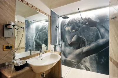 a bathroom with a shower with a sink and a mirror at Hotel Barberini in Rome