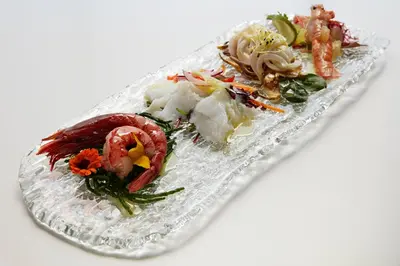 a plate of food with shrimp and vegetables on it at The Code Hotel in Rome