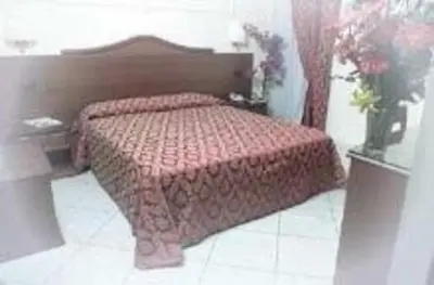 a bedroom with a bed with a red comforter at Hotel Mirage in Rome