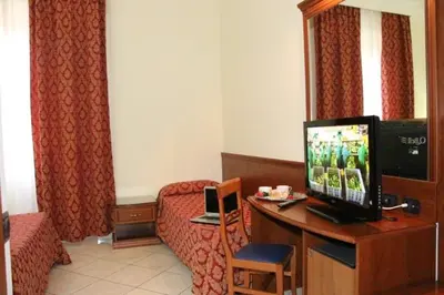 a hotel room with a bed and a television on a desk at Hotel Mirage in Rome