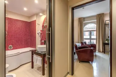 a hotel room with a bed and two chairs at La Griffe Hotel Roma in Rome