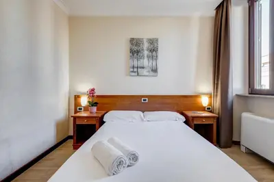 a bedroom with a white bed with towels on it at Romoli Hotel in Rome