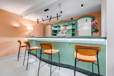 a green bar with orange chairs in a restaurant at Romoli Hotel in Rome