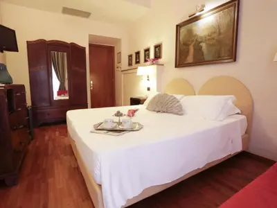a bedroom with a large white bed with a tray on it at Hotel Sant'Angelo in Rome