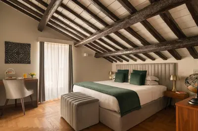 a bedroom with a large bed with green pillows at Antico Albergo del Sole al Pantheon in Rome