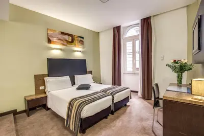 a hotel room with a bed and a desk at Hotel Rinascimento in Rome