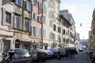 a street with cars parked on the side of a building at Colosseo et Esquilino - LOCAPPART in Rome