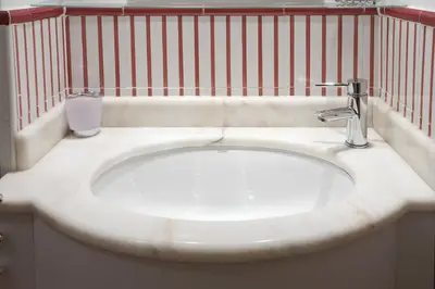 a bathroom with a white sink and a red fence at Colosseo et Esquilino - LOCAPPART in Rome