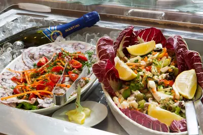 two plates of food sitting on a buffet table at Golden Tulip Rome Piram in Rome