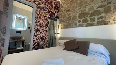 a bedroom with a bed and a stone wall at Hotel Felice in Rome