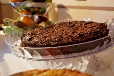 a chocolate cake on a glass plate on a table at Hotel Lirico in Rome