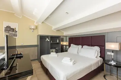 a hotel room with a large bed with white sheets at Hotel Castellino Roma in Rome