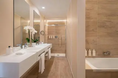 a white bathroom with two sinks and a shower at Sina Bernini Bristol, Autograph Collection in Rome