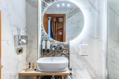 a bathroom with a sink and a mirror at Hotel Raffaello - Sure Hotel Collection by Best Western in Rome