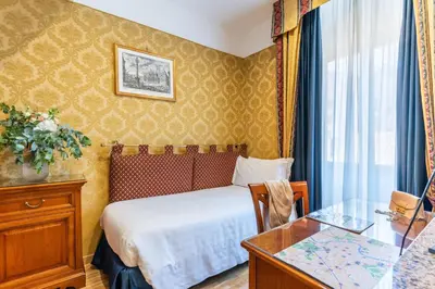 a hotel room with a bed and a desk at Hotel Raffaello - Sure Hotel Collection by Best Western in Rome