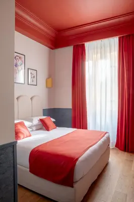 a bedroom with a large bed with red curtains at Hotel Montecarlo in Rome