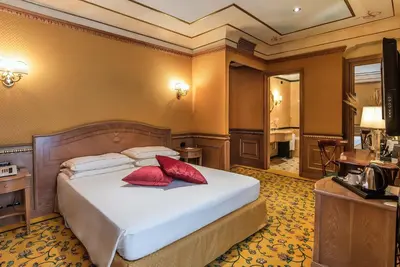 a bedroom with a bed with red pillows on it at River Palace Hotel in Rome
