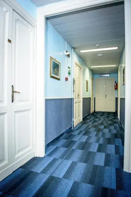 an empty hallway with a door and a tile floor at Hotel Emmaus in Rome