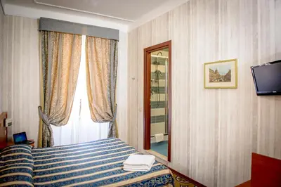 a hotel room with a bed and a window at Hotel Emmaus in Rome