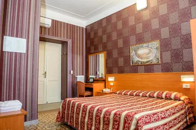 a hotel room with a bed and a desk at Hotel Emmaus in Rome