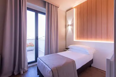 a bedroom with a bed and a large window at Garner Hotel Rome Aurelia by IHG in Rome